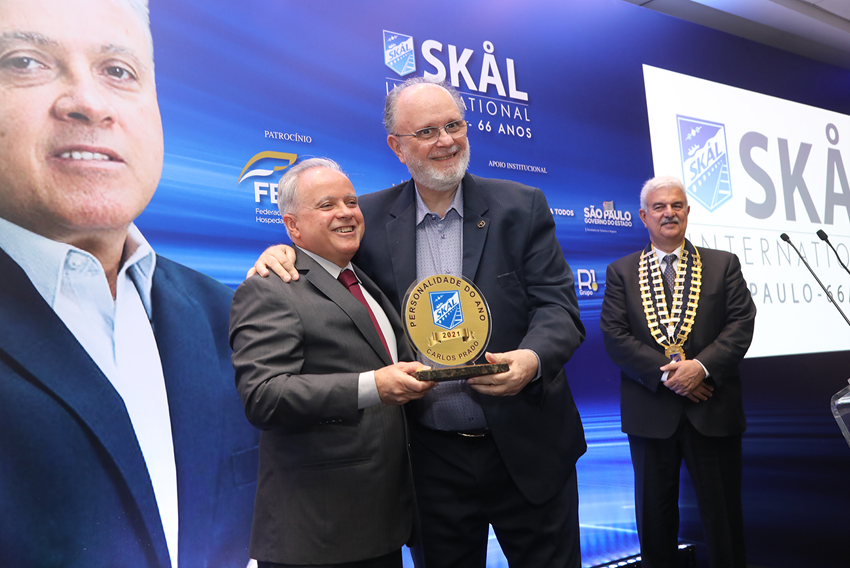 Carlos Prado receives the 2021 SKÅL Personality trophy from Sérgio Junqueira, the last SKÅL Personality in 2019.